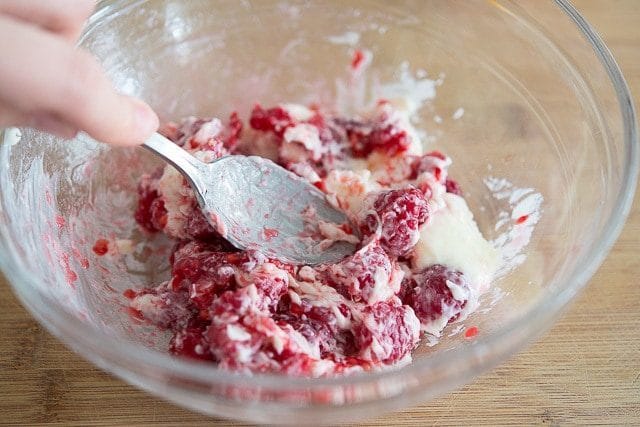 Smashing Raspberries with Spoon Into Butter