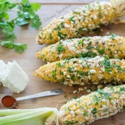 Mexican Corn Cobs on Board with Cilantro and Cheese