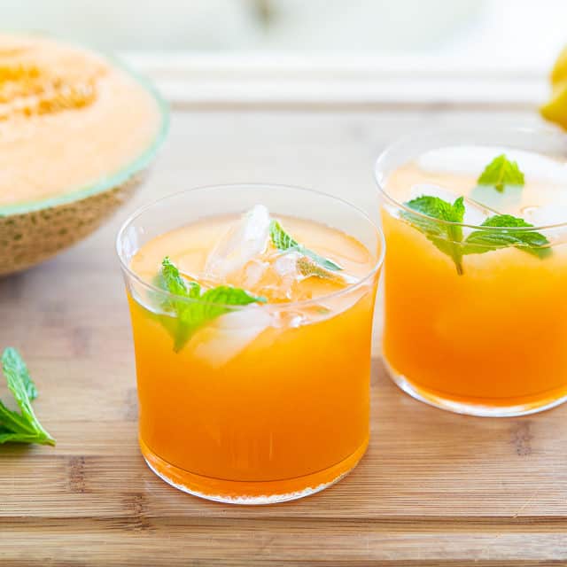 Cantaloupe Agua Fresca in two glasses with mint