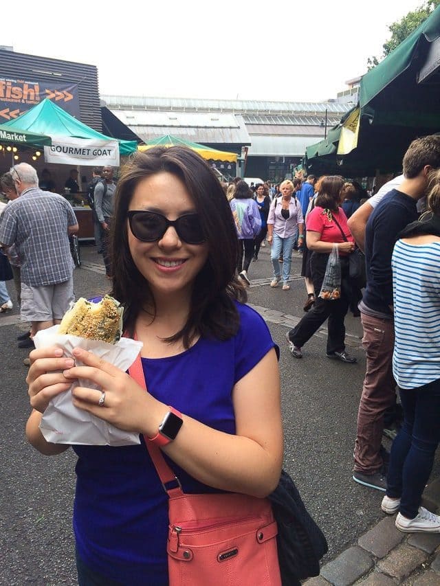 Joanne Ozug holding food at London food market
