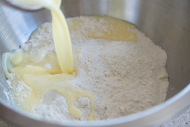 Pouring Wet Ingredients Into Flour Butter Mixture in Stainless Steel Bowl
