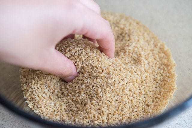 Hand In Bowl of Bulgur Wheat Raw