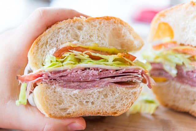 Italian Sandwich - Held By Hand to Show Interior View with Salami Meats