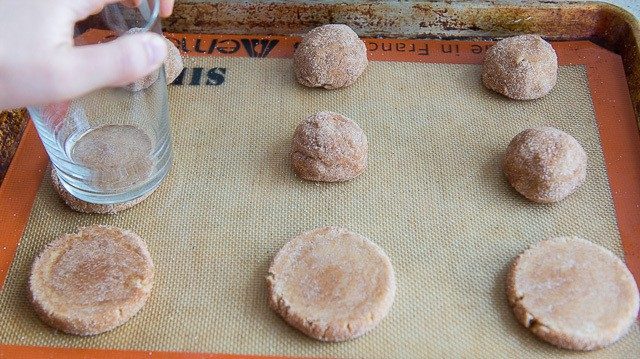 Flattening the Dough Balls On Silicone Mat Using a Glass