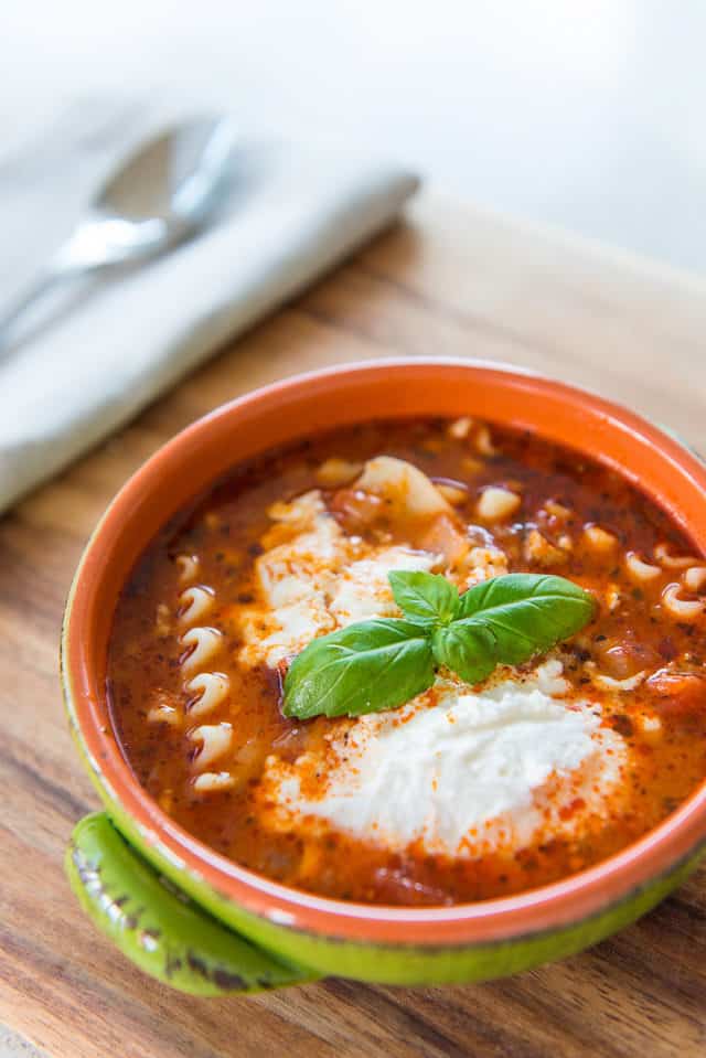 Lasagna Soup - In Green Bowl with Basil garnish and Ricotta On Top 