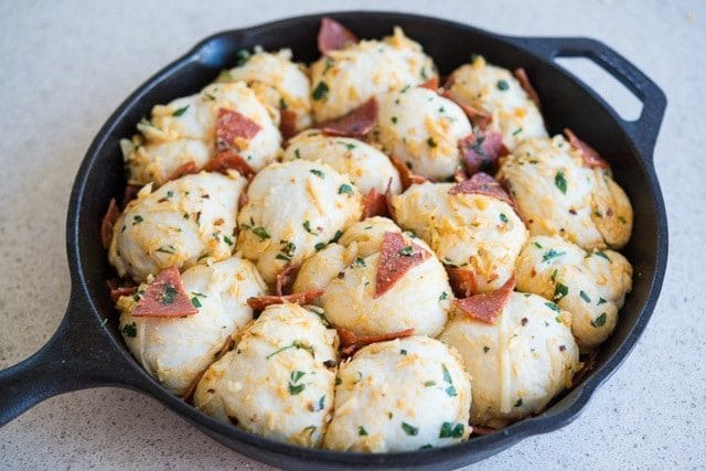 Raw Pizza Knots with Herbs and Pepperoni in Cast Iron