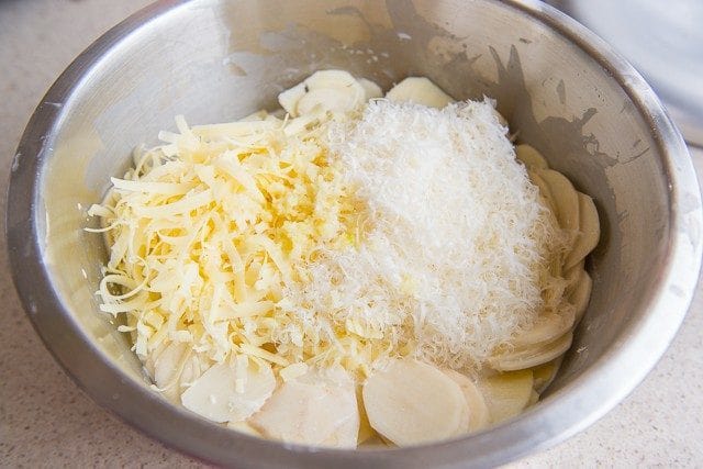 Potatoes Au Gratin Ingredients in Bowl with Cheeses and Potato Rounds