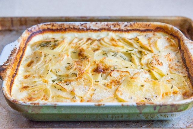 Au Gratin Potatoes Recipe Baked in Green Dish with Caramelized Dairy on Sides of Pan