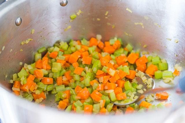 Softened Chopped Onion, Celery, and Carrot in Soup Pot with Spoon
