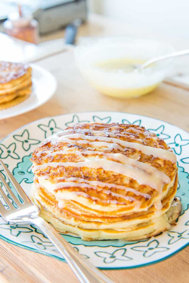 Cinnamon Roll Pancakes - Stacked on a Plate with Cream Cheese Icing Drizzle