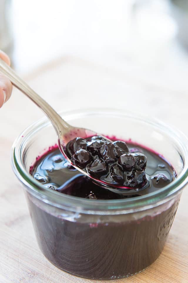 Blueberry Sauce - In a Glass Jar with Spoon Showing Cooked Soft Blueberries