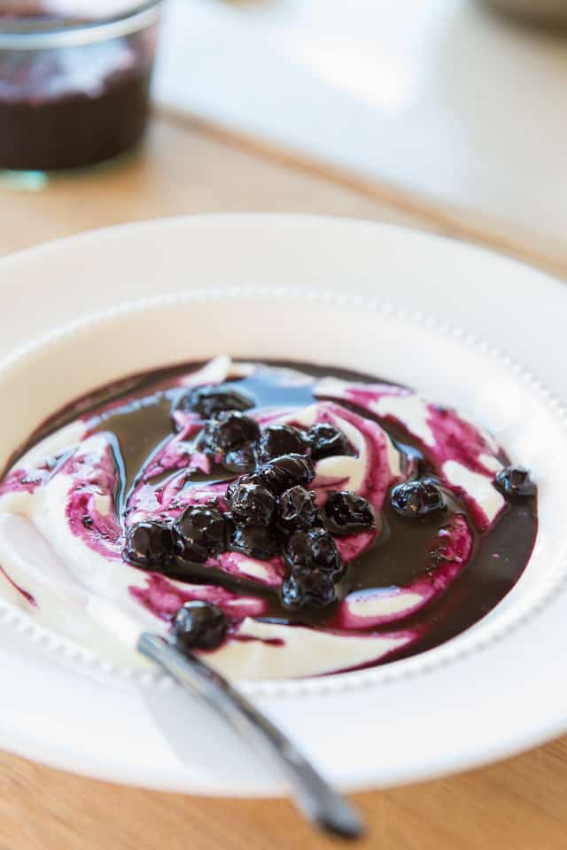 Blueberry Sauce Swirled in with Yogurt In a Bowl
