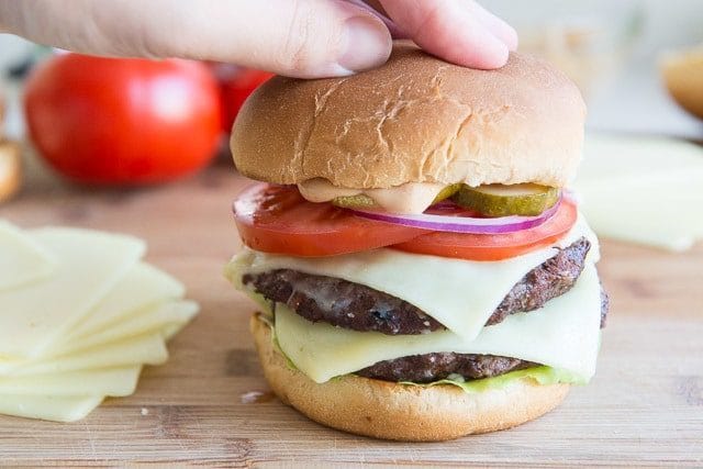 Pressing Homemade Burger Down with Hand to Compress