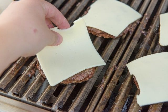 Adding Slices of Cheese to Grilled Beef Patties