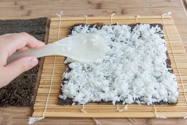 Spreading Sushi Rice on Seaweed Paper with Rice Paddle