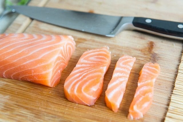 Sashimi Grade Salmon Pieces Sliced on Wooden Board