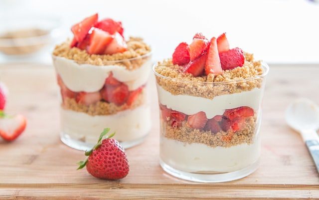 Cheesecake Parfait - in glasses with Fresh Strawberries, Cheesecake Layers, and Graham Crackers