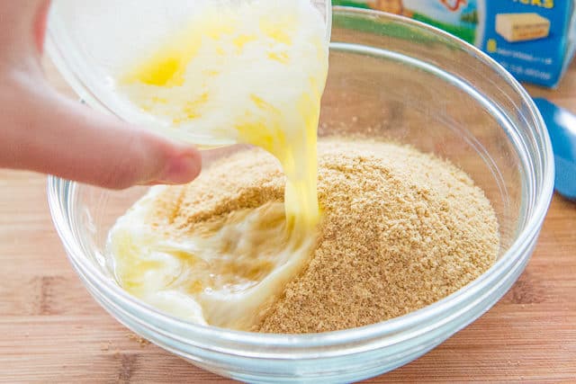 Adding Butter to Graham Cracker Crumbs in Bowl
