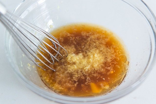 Ginger and garlic In Glass Bowl with Soy Sauce and Whisk