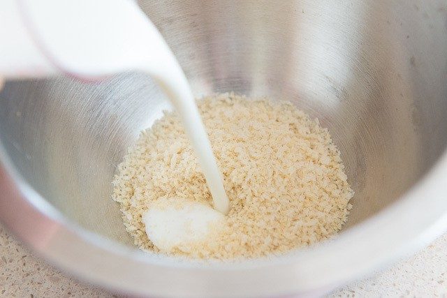 Pouring Milk Into Panko Bread Crumbs in Bowl
