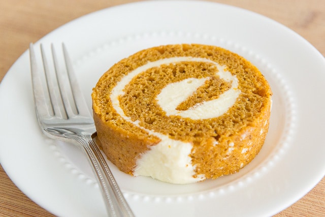 Slice of Pumpkin Roll Cake on a White Plate with Fork
