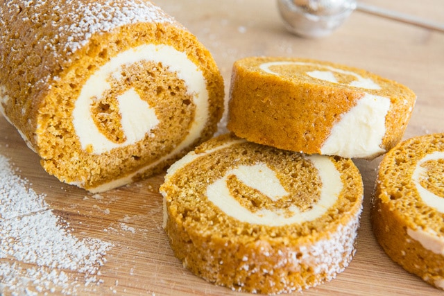 Pumpkin Roll Cake - In Slices and Partial Loaf on Wooden Board