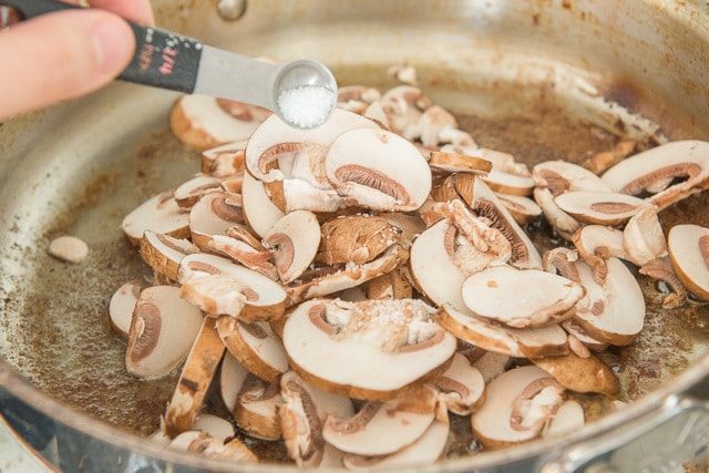Mushroom Sauce - Adding Sliced Baby Bella Mushrooms to Pan with Beef Drippings and Salt
