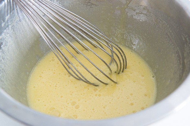 Whisked Egg and Oil Mixture in Stainless Steel Bowl with Whisk