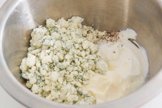 Blue Cheese Crumbles, Mayonnaise, Sour Cream, and Seasoning in a Mixing Bowl