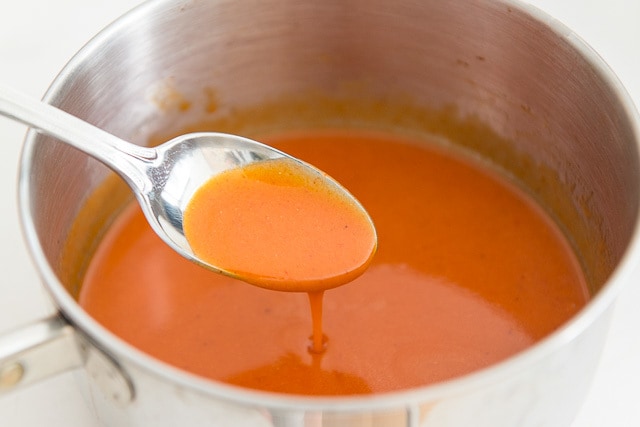 Buffalo Sauce - Dripping From Spoon Into Saucepan