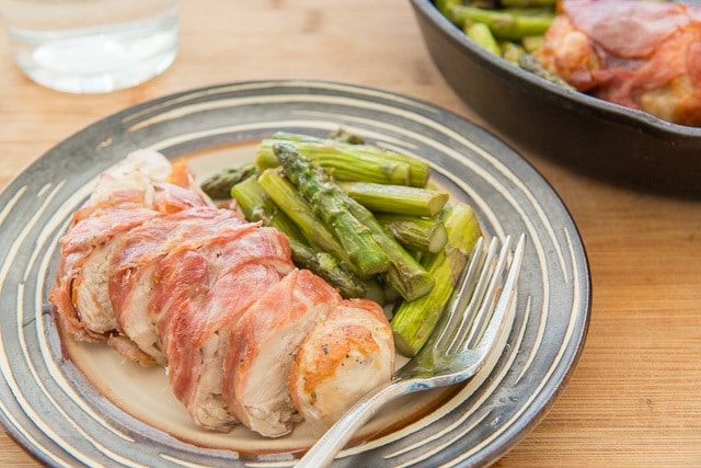 Sliced Prosciutto Wrapped chicken slice with asparagus On Plate