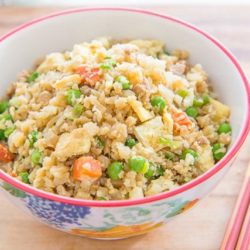 Cauliflower Chicken Fried Rice - In a Bowl on a Wooden Board with Chopsticks