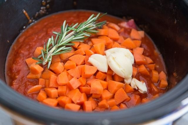 Beef Ragu Recipe in Crockpot with Rosemary, Carrots, and Garlic Over Tomato Sauce and Beef