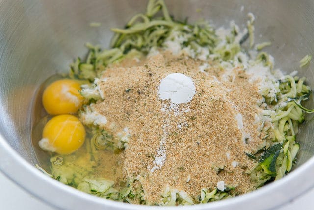 Raw Zucchini Shreds, Bread Crumbs, Baking Powder, and Eggs in a Bowl
