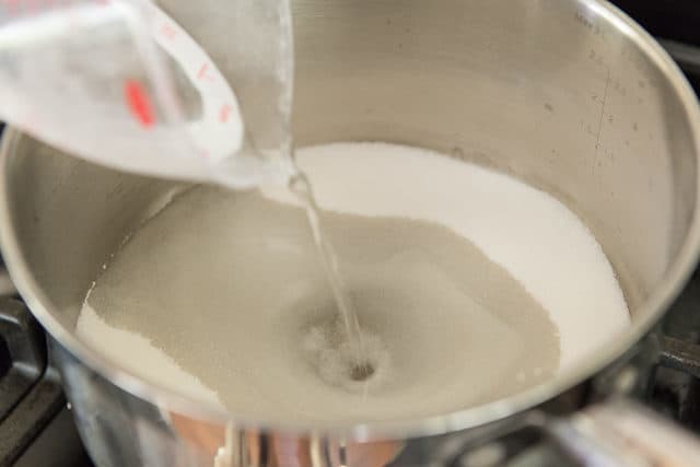 Pouring Water Into Saucepan with Granulated Sugar