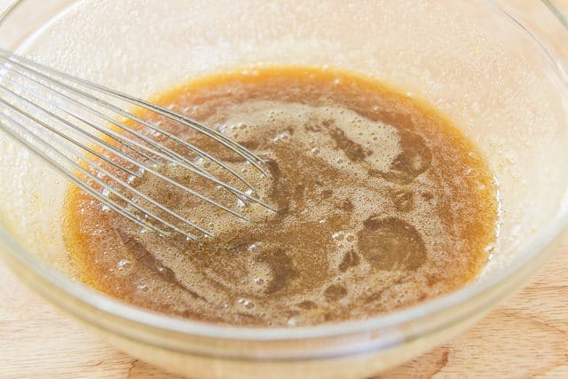 Mixture of Maple Syrup, Eggs, and Brown Sugar, in Glass Duralex Bowl and Whisk