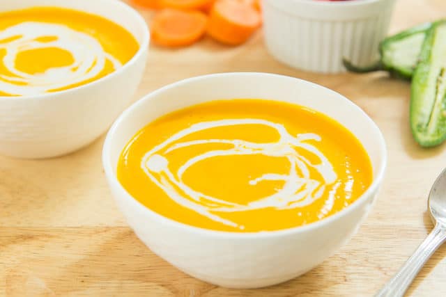 Creamy Blended Carrot Coconut Soup In Mikasa White Porcelain Bowl With Coconut Cream Swirl On Top