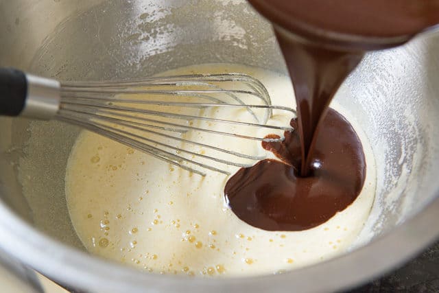 Pouring in Melted Chocolate And Butter To Wet Ingredients For Candy Cane Cookies