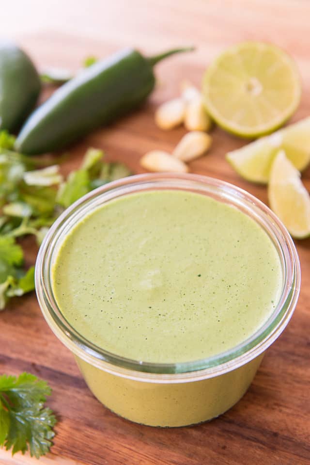 Jalapeno Sauce - In A Jar With Jalapenos, Lime, Garlic, and Cilantro on Cutting Board