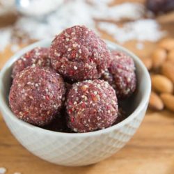 Paleo Energy Balls in a Blue Bowl with Almonds and Coconut