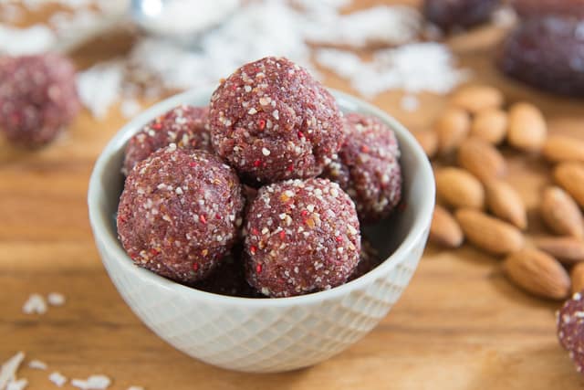 Bowl Of Raspberry Coconut Energy Bites In Light Blue Ceramic Weave Bowl