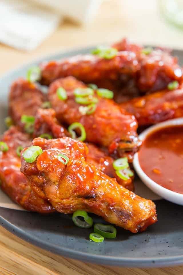 Korean Chicken Wings - With Scallions and Gochujang On Black Plate