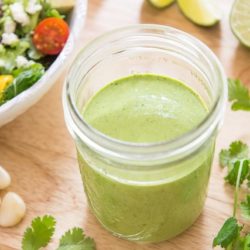 Cilantro Lime Dressing Stored in mason jar with Salad in Back