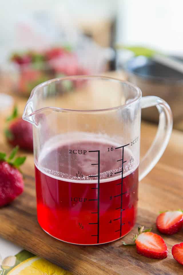 Strawberry Syrup - In Glass Measuring Cup on Cutting Board