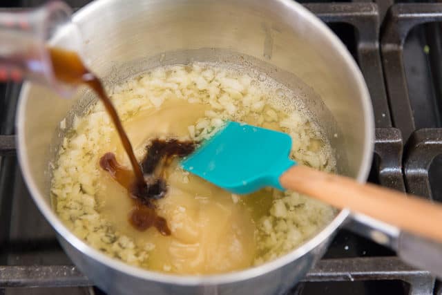 Soy Sauce Pouring into Saucepan with Garlic and Butter