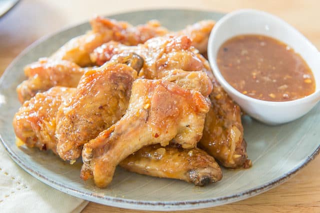 Honey Garlic Chicken Wings Recipe - Plated on a Blue Dish with white Ramekin with Dipping Sauce