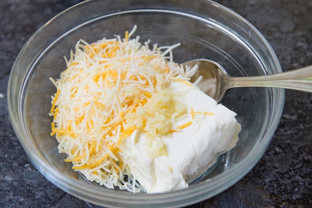 Cream Cheese, Shredded Cheese, and Garlic in a Glass Bowl