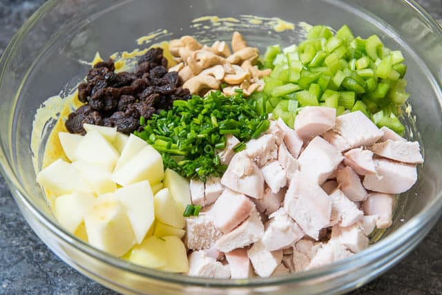 Chopped Chicken, Apple, raisins, Celery, Cashews, and Chives in a Mixing Bowl