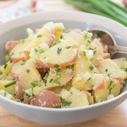 Red Potato Salad In a Gray Bowl with Fresh Herbs and Scallions