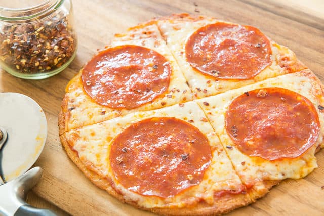 Fathead Pizza Recipe - Served on Wooden Board with Pepperoni and Red Pepper Flakes